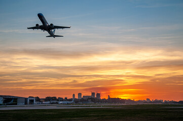 Airplane silhouette at sunset in Buenos Aires over Aeroparque Jorge Newbery airport runway