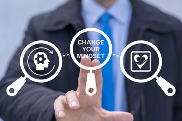 Business person using virtual touch screen presses the words CHANGE YOUR MINDSET. Change Your...