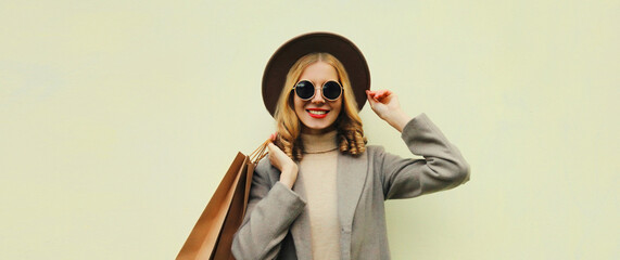 Autumn portrait of beautiful young woman with shopping bag, stylish girl in hat on white background