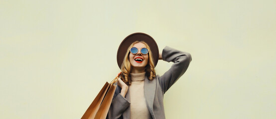 Autumn portrait of cheerful young woman with shopping bag, stylish girl in coat on white background