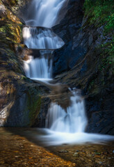 Spectacular tiered long-exposure waterfall in the wild gorge of Feichten, Austria. A serene and powerful natural landscape in the Kaunertal valley, Tyrol.