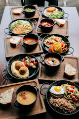 Assorted homemade lunch dishes on wooden trays served in cozy rustic restaurant setting