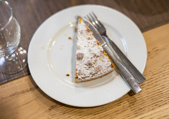 Traditional Spanish cake with almonds Tarta de Santiago on white plate. Delicious dessert with nuts according to a traditional Spanish recipe