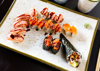 Japanese sushi set containing uramaki, nigiri and temaki served in a plate with soya-bean sauce