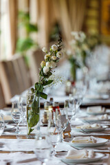 Elegant dining setup with floral centerpiece in a cozy restaurant during a daytime event
