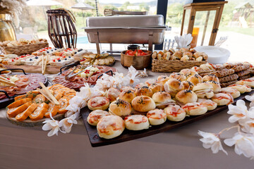 Assorted appetizers and pastries displayed at a garden gathering during sunny afternoon
