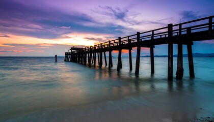 Obraz premium Wooden pier at sunset over calm water