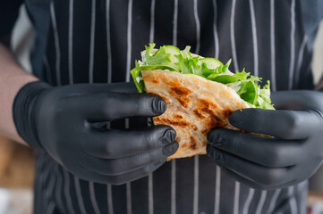 Chef holding a flatbread with herbs. 