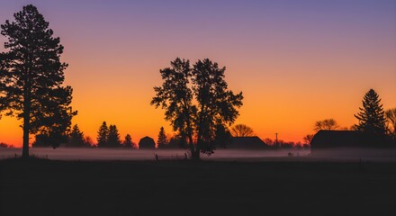 Dusk paints an orange and purple sky above silhouettes of a rural farm with creeping fog. Ideal for travel, inspirational designs, or as website headers.