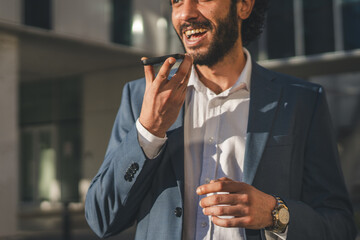 Businessman recording voice message on smart phone outdoors