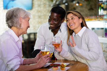 View on the young Interracial couple talking to the elder European woman