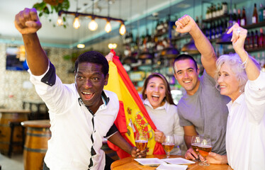 Obraz premium Happy fans celebrating the victory of Spanish team in the bar