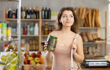 Female shopper selects canned goods in a grocery supermarket
