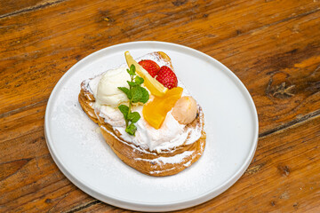 Delicious gourmet dessert with ice cream and fresh fruit on a white plate, ready to enjoy