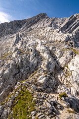 Rocky Section Of The Via Ferrata Alpspitze In The Bavarian Alps: Dramatic Cliffs And Mountain Peaks Under Scenic Blue Sky