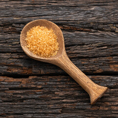 Organic brown sugar in a wooden spoon - Saccharum officinarum