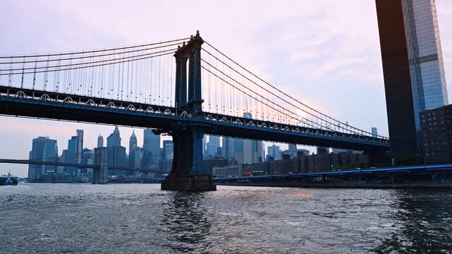 Rugged waterscape of the East River near the waterfront. Low angle view on the Manhattan Bridge and New York skyline.