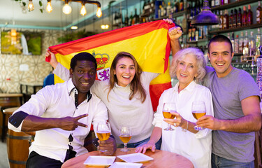 Joyful fans of the Spain team celebrating the victory in the night bar