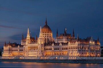Fototapeta premium Scenic view of the Hungarian Parliament Building at sunset with warm light reflecting on the Danube River