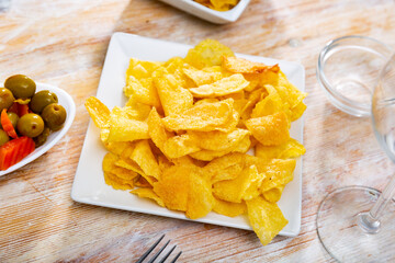 Popular beer snack in bars and cafes is potato chips and pickled olives. Snack is served with light alcoholic beverages.