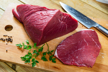 On cutting kitchen table there are fresh raw beef veal meat tenderloin. Raw beef tenderloin and...