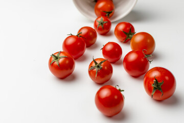 Top view flat lay of fresh ripe cherry tomatoes scattered on a white background. Concept for healthy eating, organic food, cooking ingredients, and nutrition with copy space.