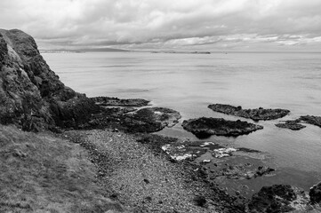 Obraz premium A rocky shoreline with a body of water in the background