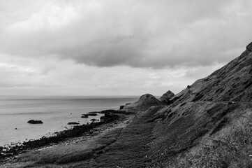 A rocky shoreline with a cloudy sky in the background