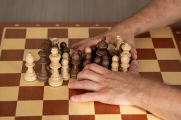 Close up of hands of middle aged caucasian man playing chess. 