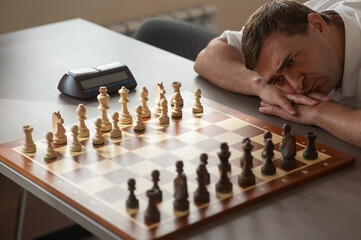 Middle aged Caucasian man playing chess. 