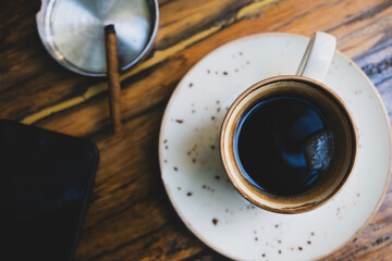 Coffee, smartphone and cigar on wooden table. Lifestyle concept with coffee, phone and cigar....