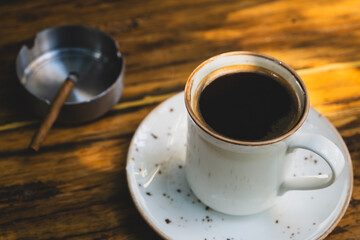 Coffee break with cigarette. Morning coffee with cigarette lifestyle concept. Addiction concept with coffee and cigarette. Cup of coffee and cigarette on table.