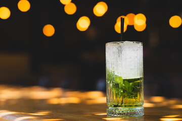 Refreshing mojito cocktail with lime and mint. Cool refreshing mojito cocktail on table. Iced mojito with mint leaves and lime. Classic mojito drink served in glass.