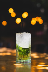 Refreshing mojito cocktail with lime and mint. Cool refreshing mojito cocktail on table. Iced mojito with mint leaves and lime. Classic mojito drink served in glass.