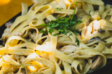 Italian fettuccine pasta with cream, chicken and mushrooms. Creamy chicken and mushroom fettuccine pasta. Freshly cooked chicken mushroom fettuccine with cream.