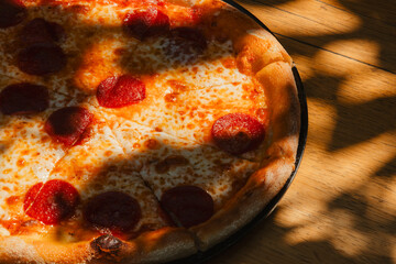 Tasty Italian pepperoni pizza on wood table. Pepperoni pizza on rustic background. Freshly baked...