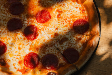 Tasty Italian pepperoni pizza on wood table. Pepperoni pizza on rustic background. Freshly baked...