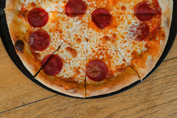Tasty Italian pepperoni pizza on wood table. Pepperoni pizza on rustic background. Freshly baked...