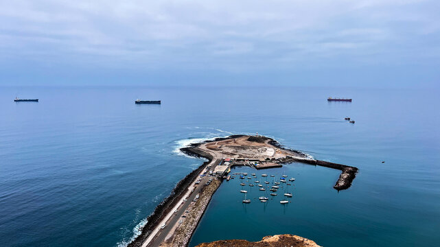 Seascape view of few huge container shops swimming around half island called Ex-Island alacr&aacute;n in Arica, Parinacota Region in Chile in South America.