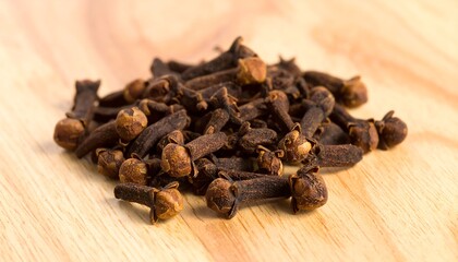 Fototapeta premium A close-up view of a pile of whole cloves resting on a light-colored wooden surface.