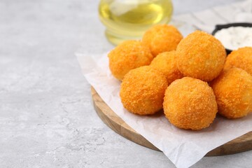 Delicious fried croquette balls on gray textured table, closeup. Space for text
