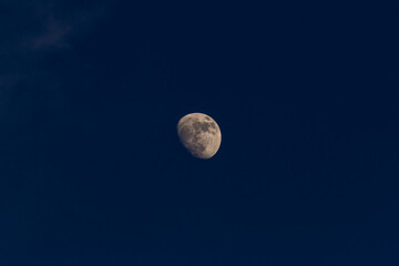 Full moon in the dark night sky with clouds. Natural background.