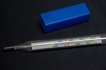 Photograph, an isolated medical thermometer on a black background.