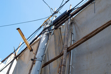 足場丸太を番線で固定して遮蔽シートを掛けた様子