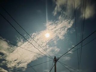 photo from under the cable on the electricity pole with the moonlight in the night sky as the...