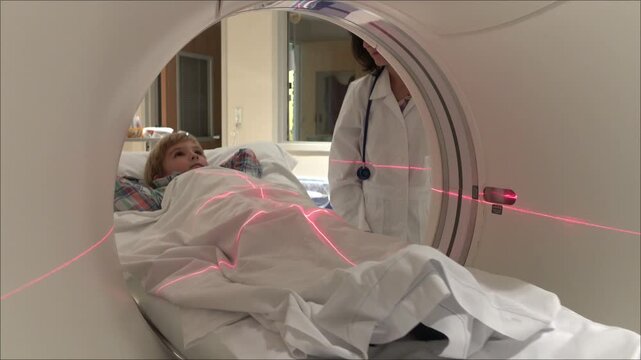 Medical Technician Assisting Boy in CAT Scan Machine
