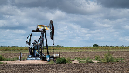 Pump Jack on a Midwest prairie with heavy clouds in the background.