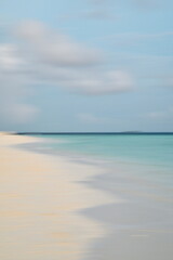 Blurred, paint-like, paradisiac beach with blue sky, turquoise water and white sand.