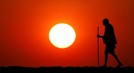 Silhouette of Mahatma Gandhi walking with stick against bright sunset sky, symbolizing peace, freedom, nonviolence, independence movement, leadership, and inspirational legacy
