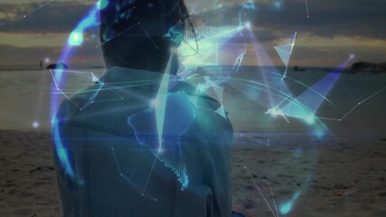 Woman sitting on beach activating geometric nodes to visualize rotating globe network in technology - Powered by Adobe